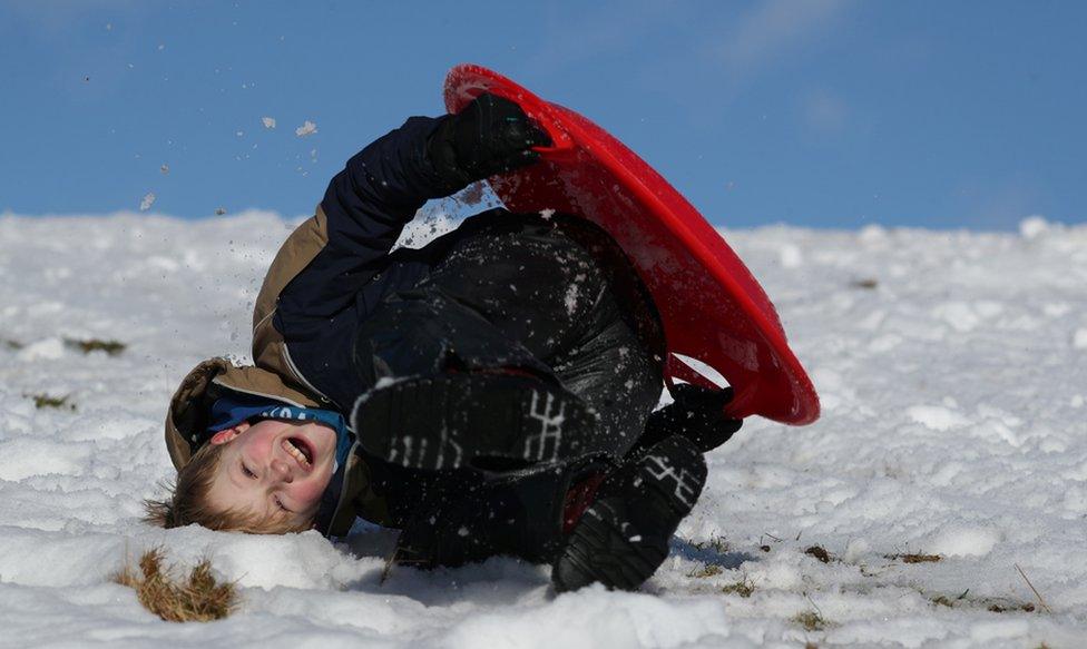 A boy sledges on a snow-covered field near Pitlochry