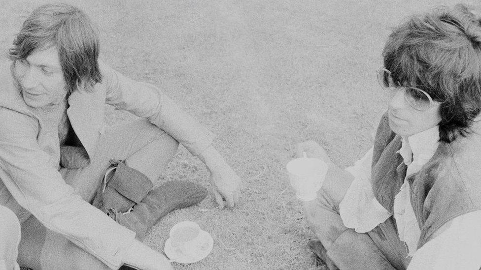 Charlie Watts and Keith Richards sitting with teacups on the floor