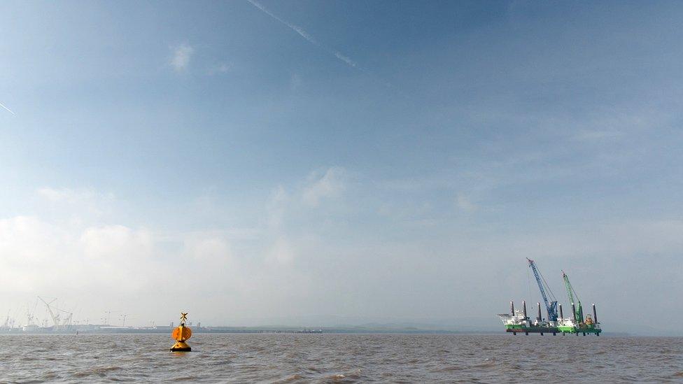 A distant view of the two giant vessels in the Bristol Chanel, with Hinkley C in the background