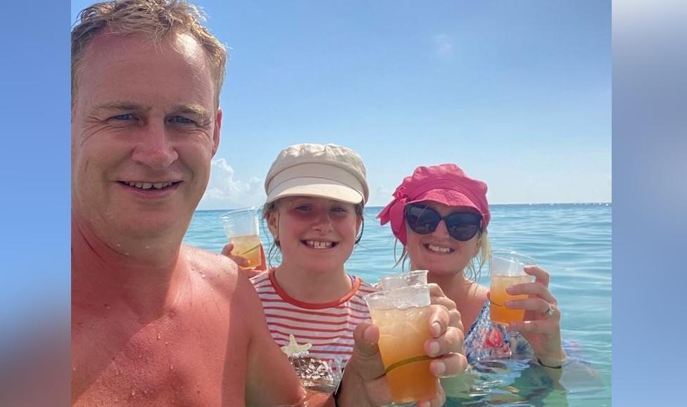 Parents and a child drinking juice in the sea