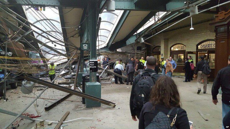 Commuters look at the felled roof at Hoboken station on 29 September 2016