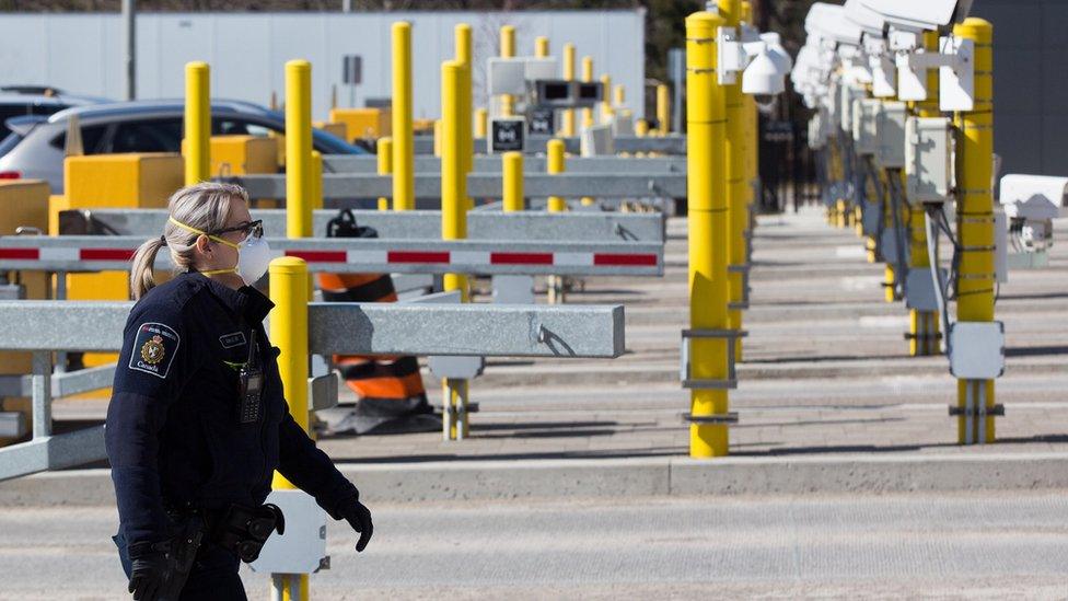 A Canadian border officer wears as face mask at the US/Canada border in Lansdowne, Ontario, on March 22, 2020.