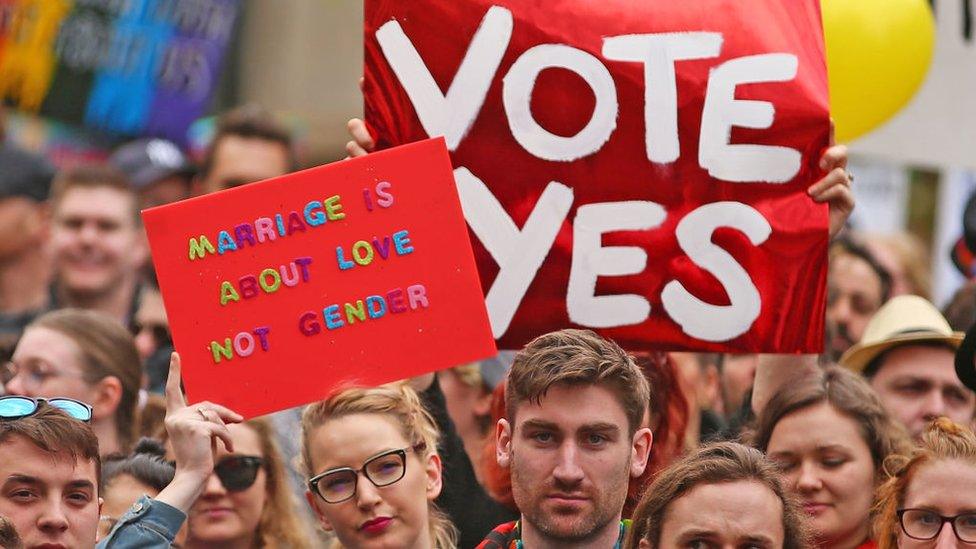 Same-sex marriage supporters hold up signs urging for marriage equality