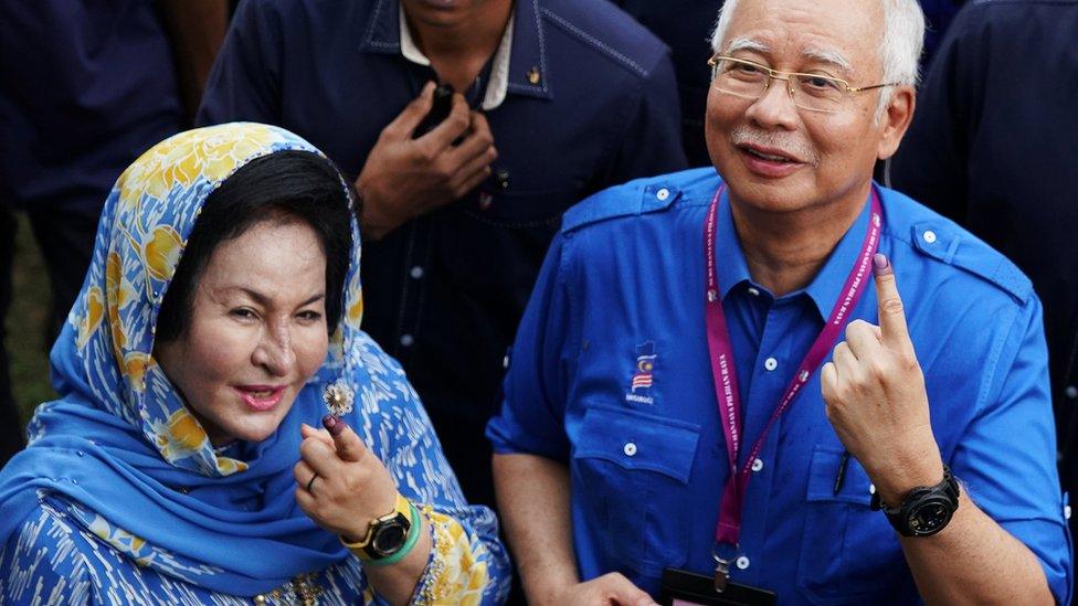 Najib Razak and his wife Rosmah show their ink-stained fingers after voting in Malaysia's general election