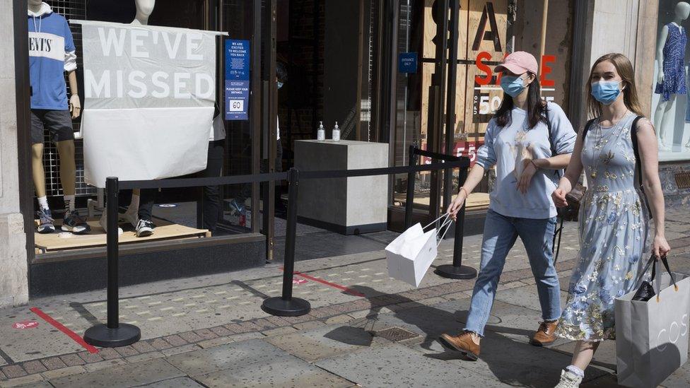 women in London walk by a levi's store