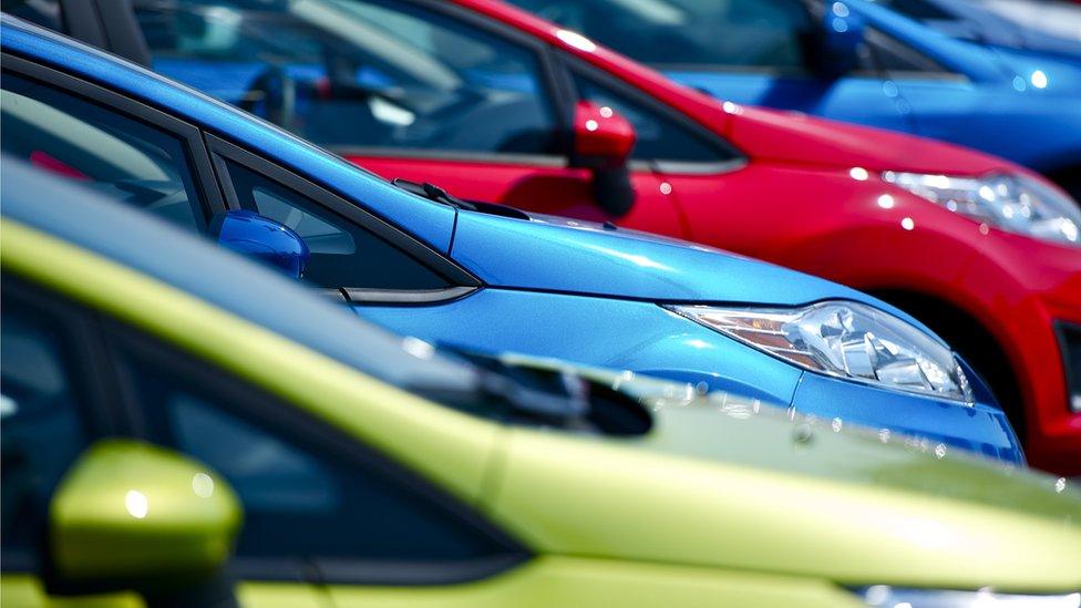 Various coloured cars parked