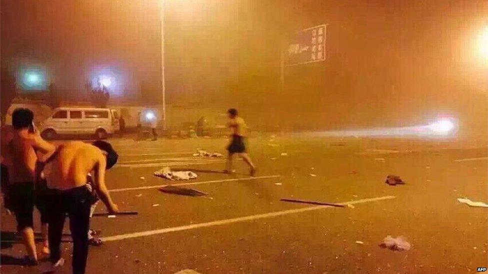 People taking shelter on a street after a huge explosion