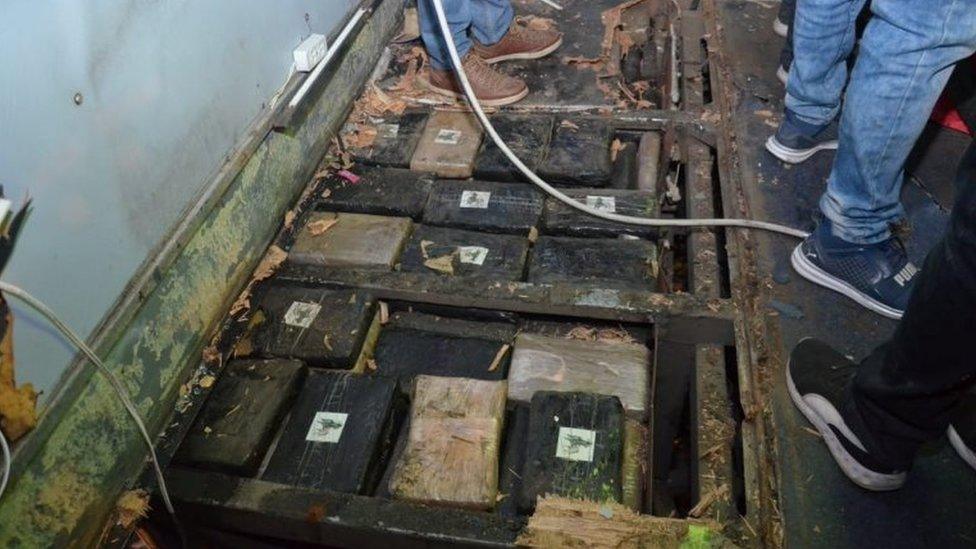 Packets of drugs can be seen stashed into a compartment under the floor of the bus