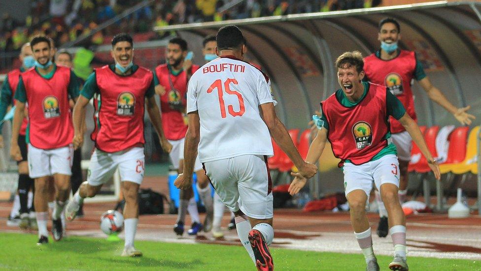 Soufiane Boutfini celebrates with team-mates after setting Morocco on their way to a second successive CHAN final