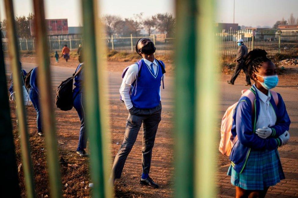 Pupils wait in line outside the school premises before classes resume in the Tembisa township, Ekurhuleni, on June 8, 2020.