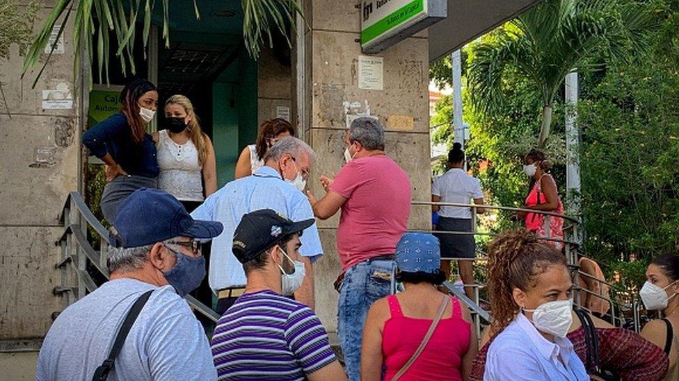 People line up outside a bank branch in Havana