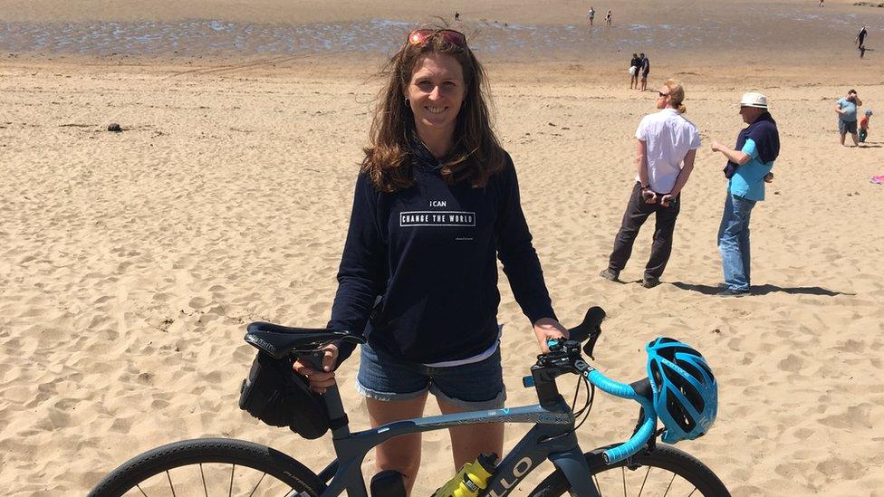 Woman with her bike on a beach