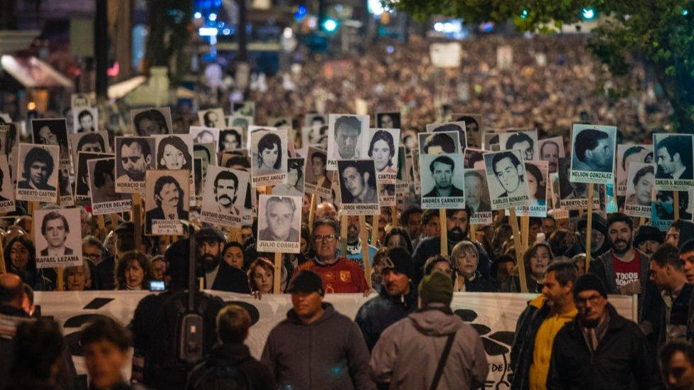 Thousands of relatives and friends carry photos with the images of the disappeared persons in the last military dictatorship in the March of Silence in Montevideo on May 20, 2023.