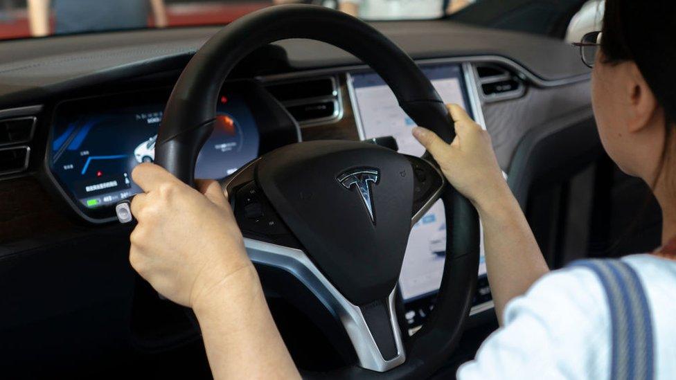 driver at wheel of Tesla