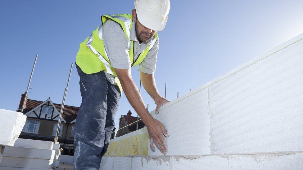 Construction worker building wall