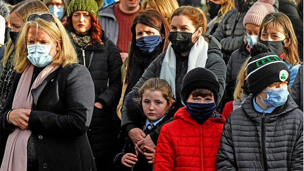 A woman embraces a girl as people arrive for the funeral of 23-year-old teacher, Ashling Murphy, who was murdered while out jogging, by the St Brigid"s Church in Mountbolus near Tullamore, Ireland January 18, 2022. REUTERS/Clodagh Kilcoyne