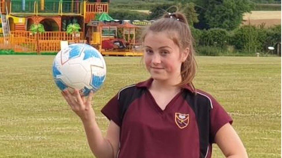 Football fan Madison holding a ball