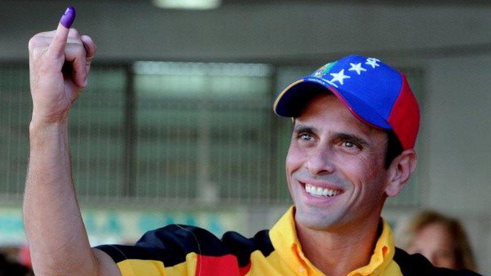 Miranda state governor and opposition leader Henrique Capriles Radonski shows his inked finger during the municipal elections in a polling station in Caracas on December 8, 2013