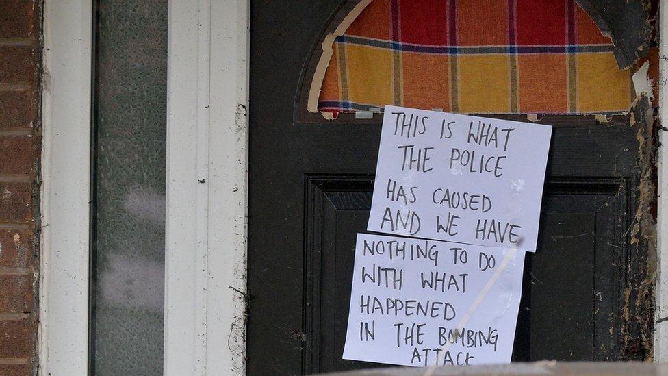 A broken door in the Moss Side area of Manchester where a raid was carried out on Sunday