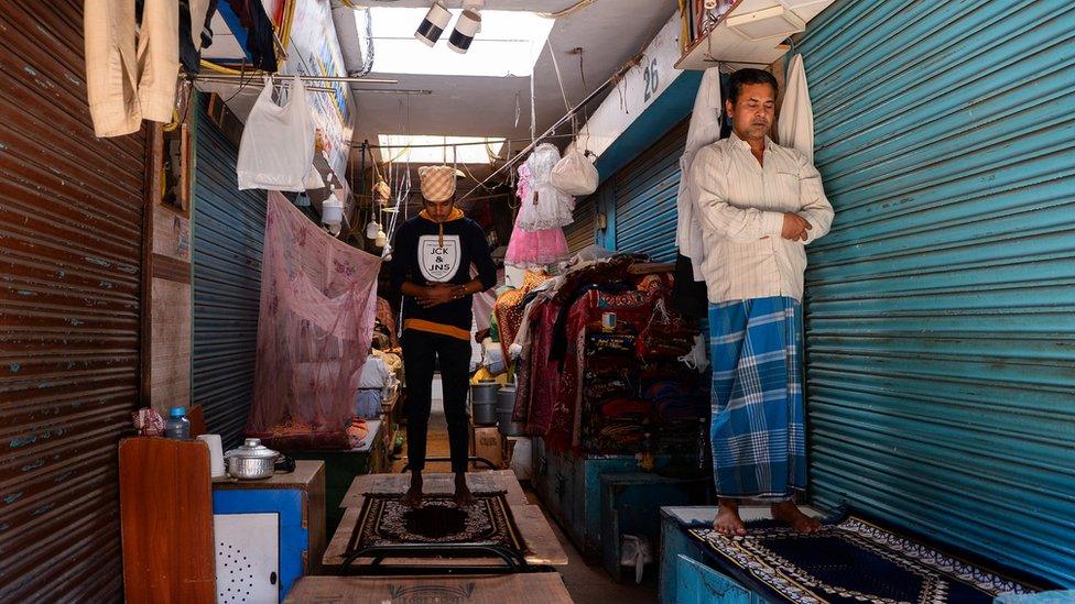 Muslim men pray in front of closed shops in New Delhi during Ramadan. Many Muslims in India fear they have been unfairly discriminated against during the pandemic