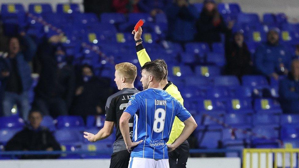 Referee and two footballers