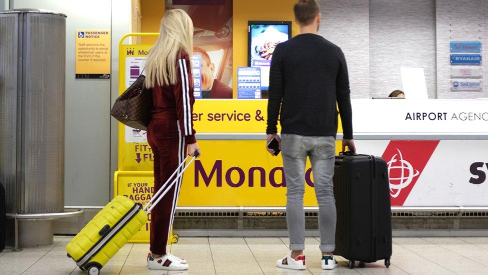 Passengers by Monarch desk at Luton airport