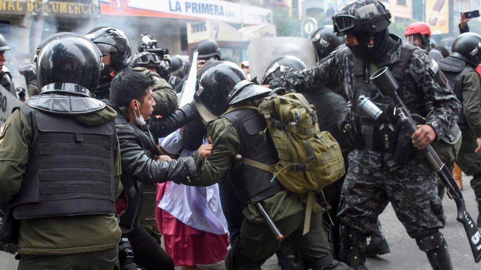 Security forces scuffle with supporters of Bolivian ex-President Evo Morales during a protest in La Paz on 13 November, 2019