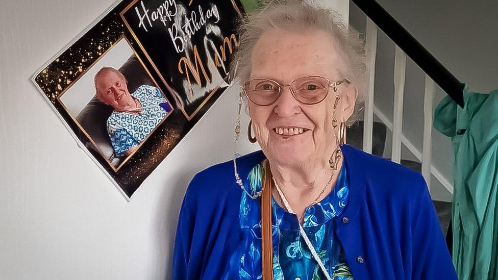 Theresa Jones smiling in front of a birthday poster