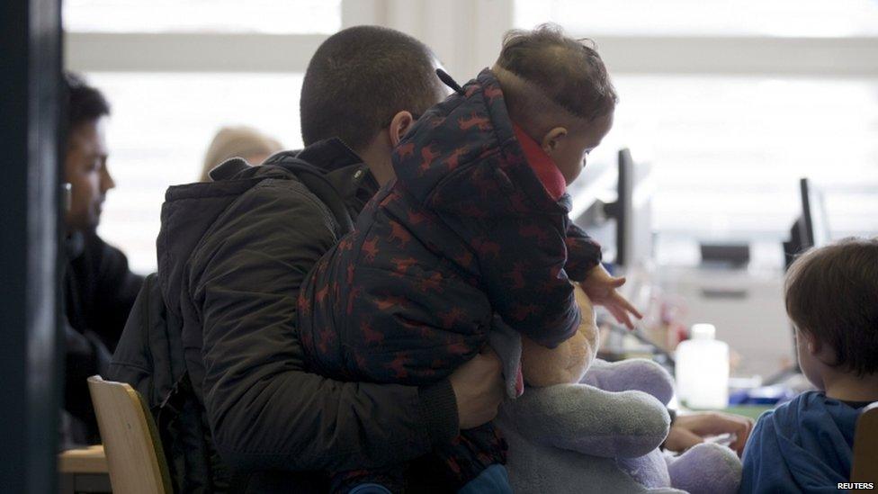 Asylum seekers wait to apply for refugee status at a Federal Office for Migration and Refugees in Berlin in March 2015