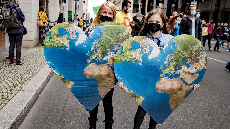 Children hold signs during a large-scale climate strike march by Fridays for Future on September 24, 2021 in Berlin, Germany.