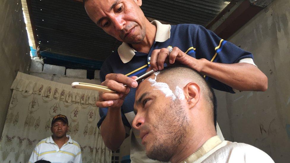 Jose Bolivar cuts a customer's hair