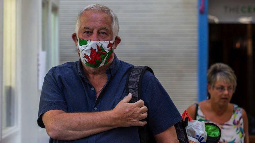 man wears a Welsh red dragon face mask in Pontypridd indoor market on May 26, 2020 in, Pontypridd, Wales,