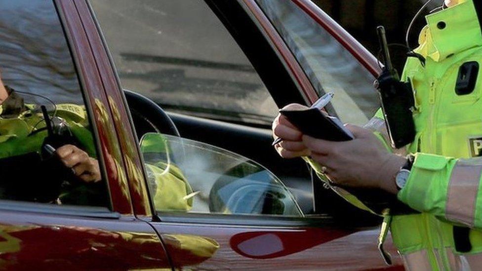 A policewoman stopping a driver