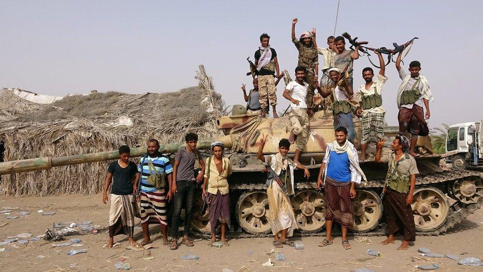 Tribal fighters allied to Yemen's government stand around a tank near Hudaydah (1 June 2018)