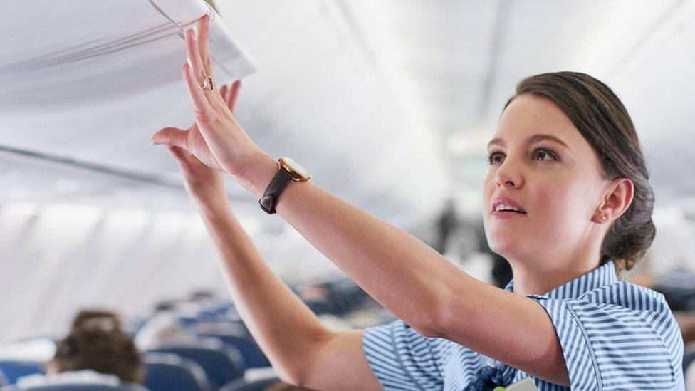 A female member of staff on a plane