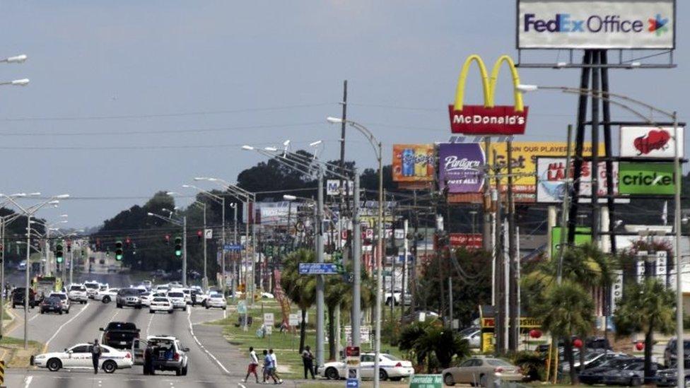 Police vehicles block access to part of Airline Highway after a fatal shooting of police officers in Baton Rouge