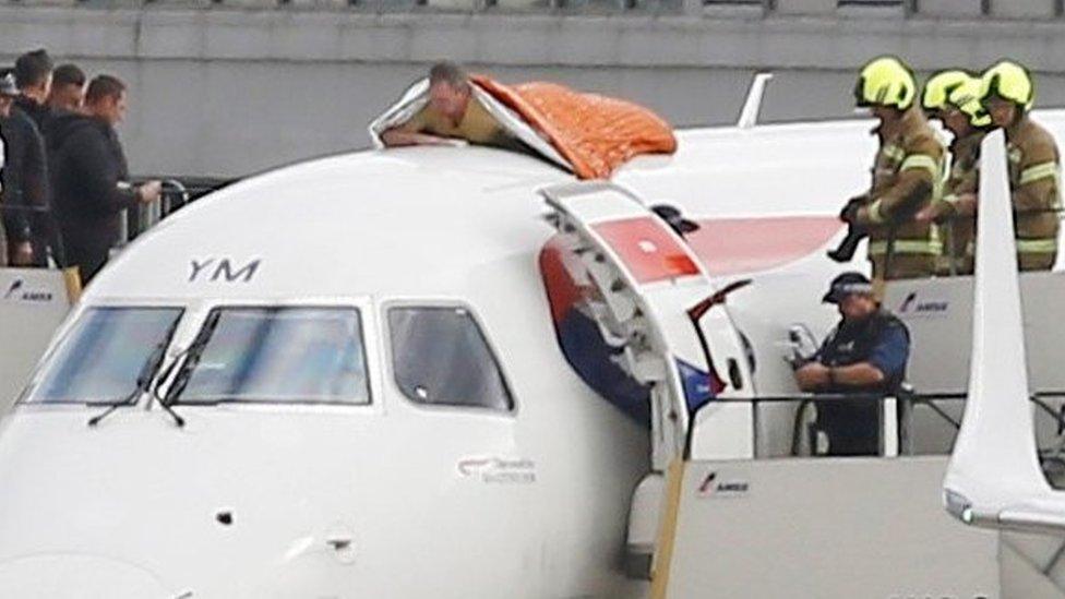 A man on top of plane at London City Airport