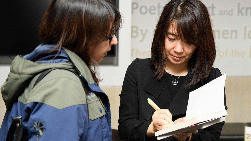 Han Kang signing a copy of her book