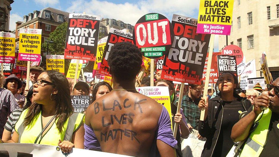 A man with the words 'Black Lives Matter' written on his back seen at the front line ahead of the march.