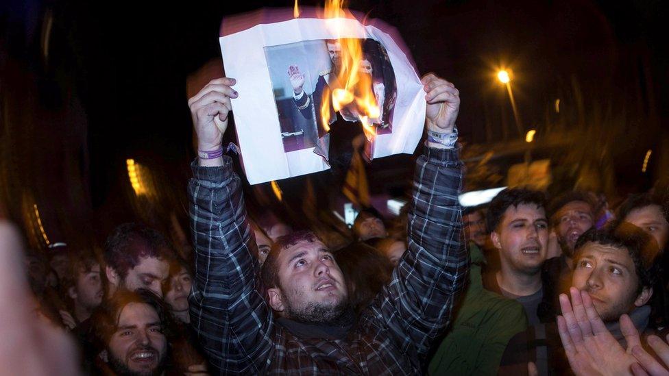 Protesters burn a picture of Spanish King Felipe VI and Queen Letizia during a protest in Barcelona, 23 March 2018