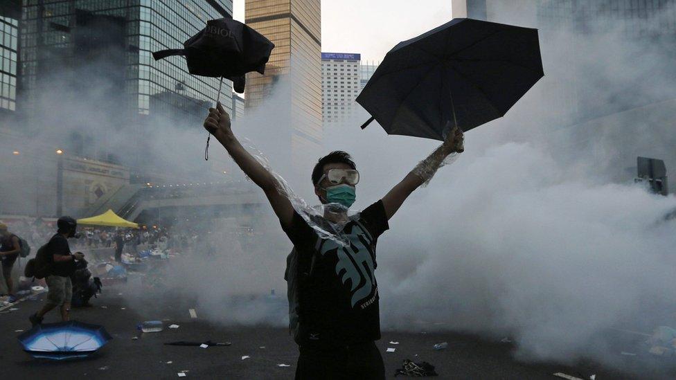 A protester raises an umbrella during demonstrations outside the government headquarters in Hong Kong, 28 September 2014