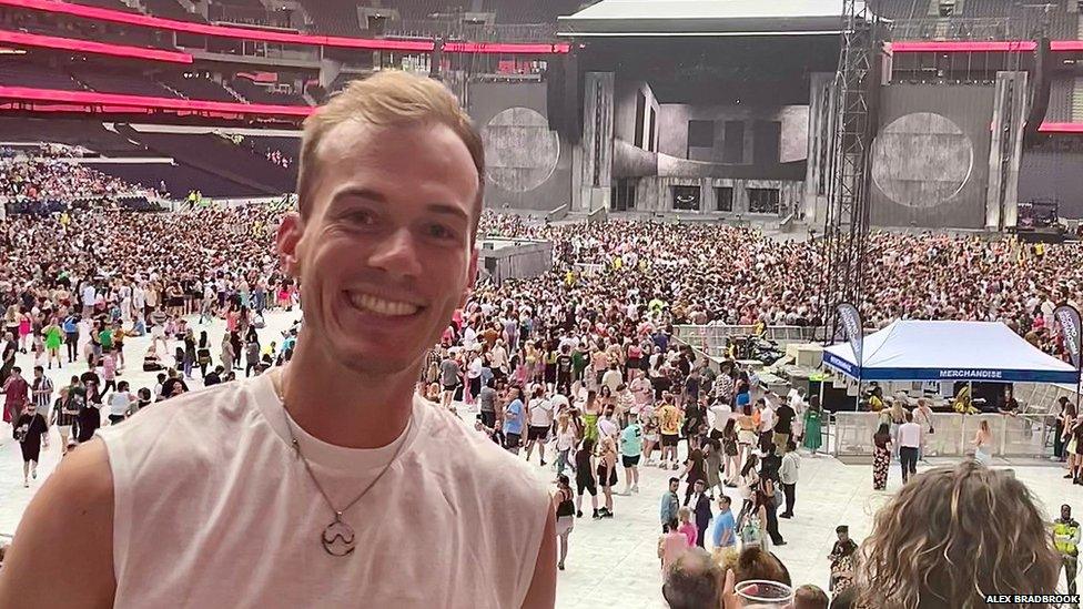 A man poses for the camera in front of a crowd at a concert