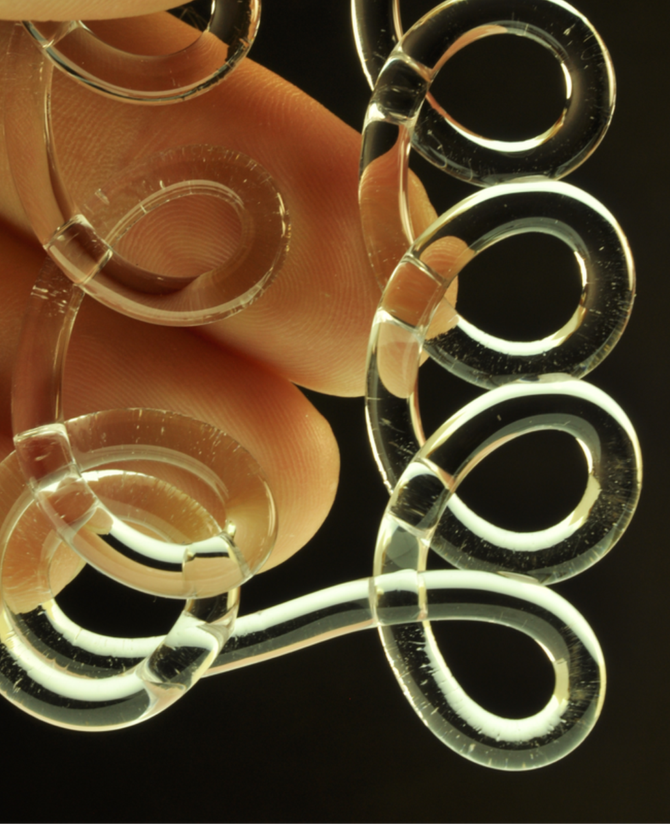 fingers holding loops of glass