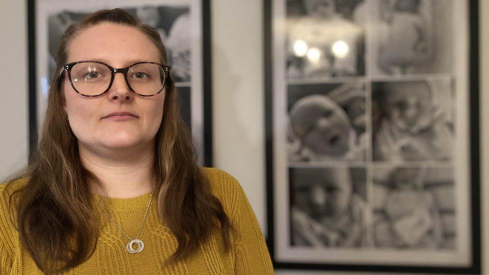 Natalie Lockyer standing in front of a compilation picture of her daughter Quinn