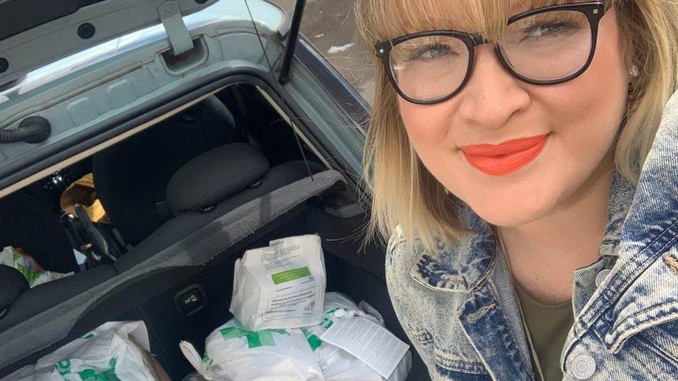 Liz is pictured in front of her car boot with medicines packed in for delivery