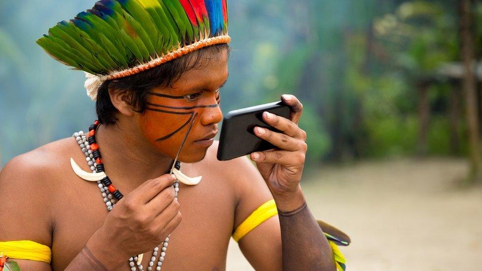 An indigenous man from the Tupi Guarani tribe in Brazil paints his face