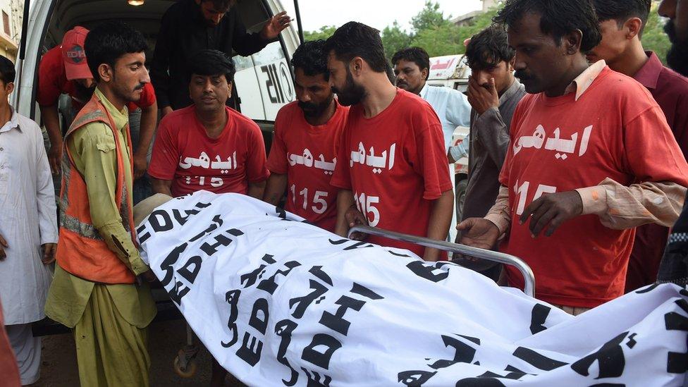 Pakistani volunteers move the dead body of convicted murderer Shafqat Hussain to a mortuary after his execution in Karachi on 4 August 2015