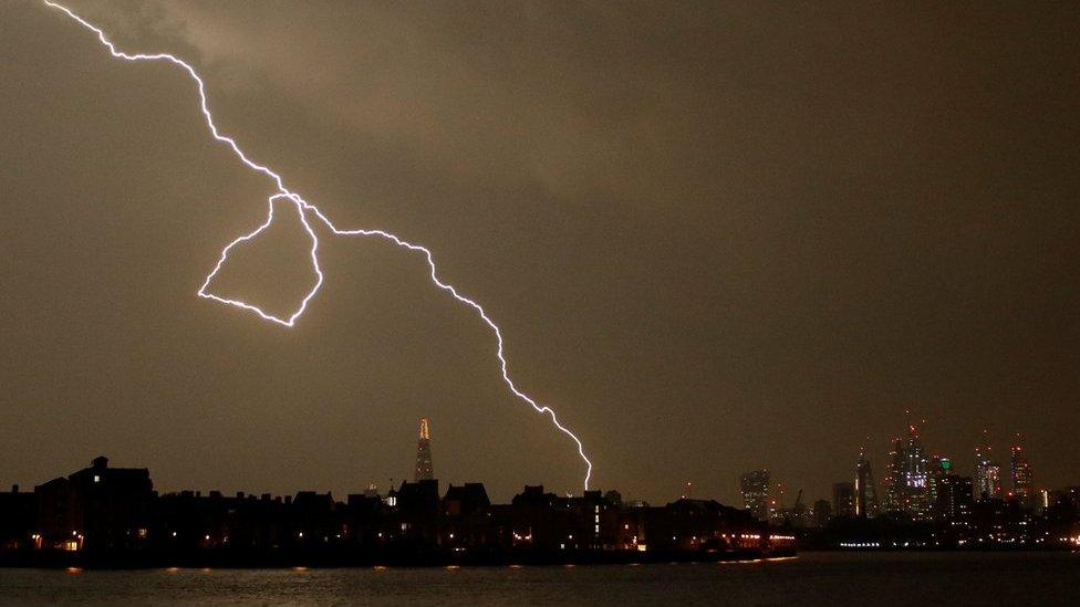 General view as lightning strikes over the city of London