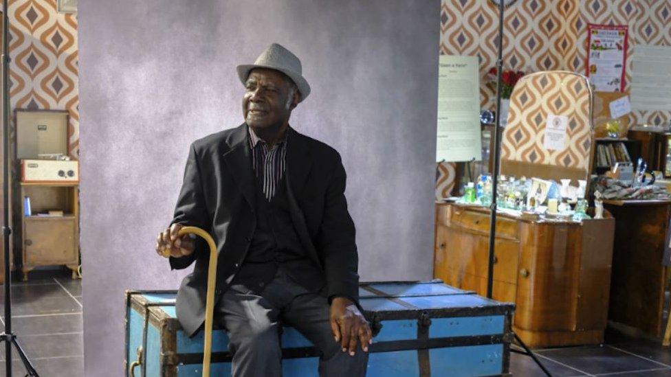 Eglon, a man sat down with his stick, wearing a suit and hat