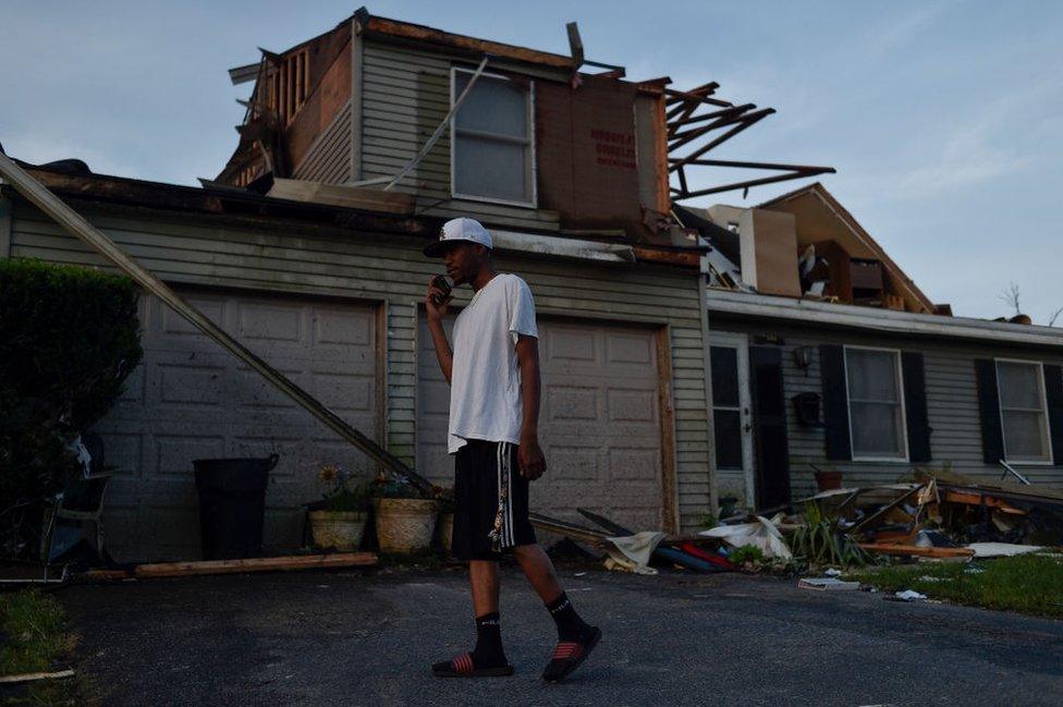 A resident inspects home damage